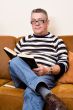 Senior reading his book on the couch