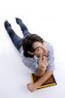 young fellow lying on floor with his books