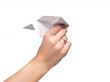 The female hand starts the paper plane. Isolated.