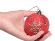 The female hand holds a Christmas ornament