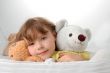 Young girl lying on the floor with toys