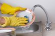 Man hands in, washing the dishes at the kitchen