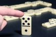 Human fingers push a dominoes.