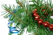 Fir tree branch with cristmas decoration on a white background.