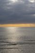 Yellow sunset over the sea with dark clouds