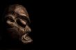 African mask over black background