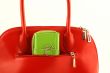 Green wallet in red handbag`s pocket