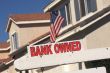 Bank Owned Real Estate Sign and House with American Flag