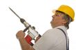 Worker with drilling machine and safety helmet