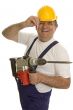 Worker with drilling machine and safety helmet