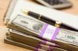 Stack of Money, Calculator, Paper and Pen
