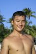 Fit asian man smiling on beach