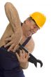Plumber with pipe wrench and safety helmet
