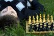 Woman lying in the grass near the chess board