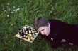 Woman lying in the grass near the chess board