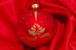 red christmas ball on soft red fabric with copy space