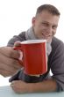 handsome young man showing coffee mug