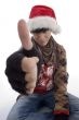 young boy wearing christmas hat showing thumb