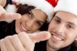 young couple wearing christmas hat and looking