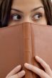 student peeping from book