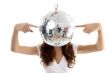 woman balancing mirror ball with fingers
