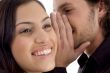 young man whispering to woman
