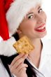 woman with christmas hat and holding biscuit
