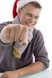 smiling young man with christmas hat showing punch