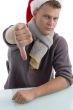 young man with christmas hat showing thumb down
