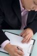 businessman writing on writing pad