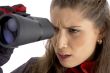 female viewing through  binoculars