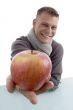 smiling male showing apple