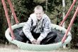 Happy blond boy in the swing