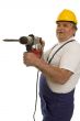 Worker with drilling machine and safety helmet
