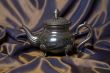 Teapot on a grey drapery background