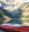 canoes by a lake and mountains