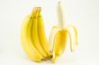 Four bananas on light background