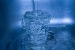 Water flowing in glass in dark blue tones