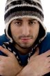 man wearing winter cap shivering from cold