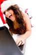 woman wearing christmas hat and working on laptop