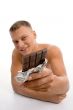 smiling muscular man showing chocolate