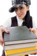 student in cap holding stack of books