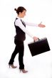businesswoman holding bag and offering handshake