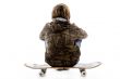 back pose of boy sitting on skateboard