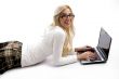 female lying down on floor and working on laptop