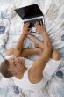 high angle view of smiling man working on laptop