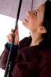 side view of smiling woman looking umbrella
