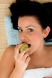 smiling woman eating apple in spa