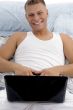 smiling guy posing with laptop