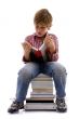 front view of boy sitting on books
